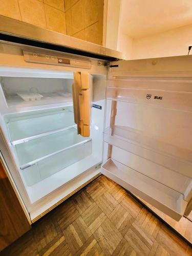 an empty refrigerator with its door open in a kitchen at City Center Flats with Balcony Garden View Rigi Self Checkin in Zürich