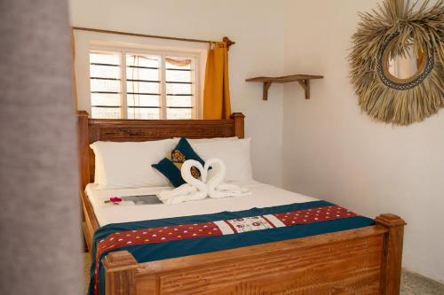 a bedroom with a bed with two swans on it at ZAN Uhuru Beach in Jambiani