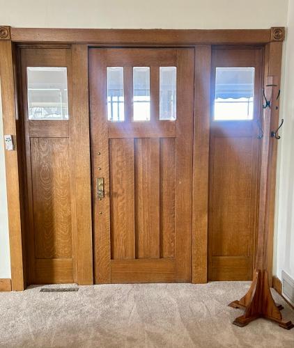a pair of wooden doors in a room at Colossal Craftsman in Hastings