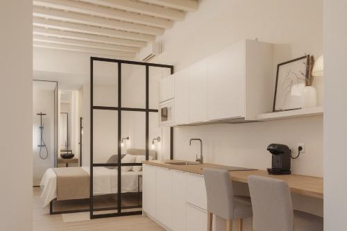 a kitchen with white cabinets and a bed in a room at Suites Alfonso X in Jerez de la Frontera