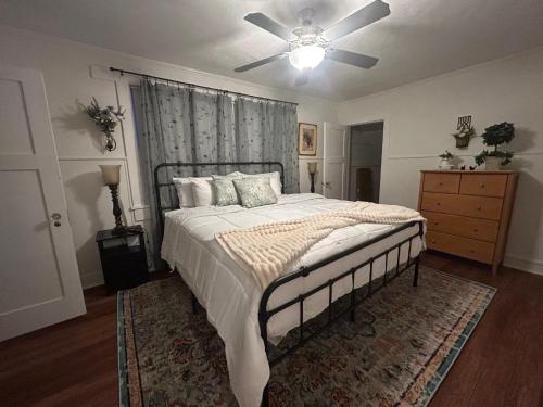 a bedroom with a bed with a ceiling fan at Colossal Craftsman in Hastings