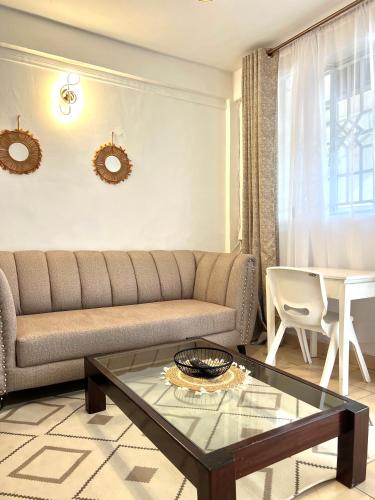 a living room with a couch and a table at Cozy 1br milimani in Kisumu