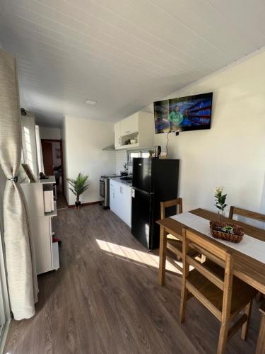 eine Küche und ein Esszimmer mit einem Tisch und einem Kühlschrank in der Unterkunft Casa contenedor VoVo in Barra de Portezuelo