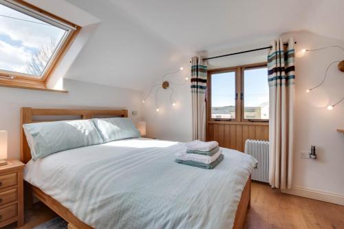 a bedroom with a bed and two windows at The Hop House in Welcombe