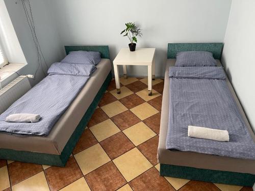 two beds in a small room with a table at Lawendowa Przystań - Dolina Baryczy in Ujeździec Mały