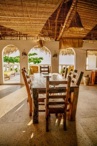 a dining room with a wooden table and chairs at ZAN Uhuru Beach in Jambiani