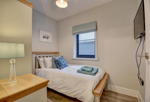 Un dormitorio pequeño con una cama y una ventana. en Hectors House, en Croyde