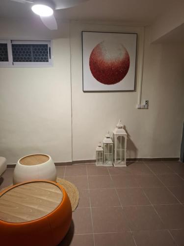 a room with an orange stool and a painting on the wall at Chez les Loulou in Pamandzi