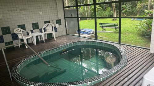 a house with a pool with two chairs and a table at Mata Atlântica Park Hotel in Matinhos