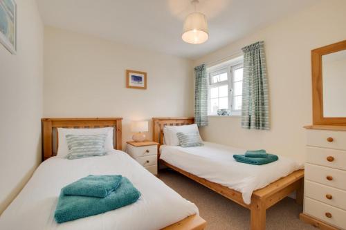 2 camas individuales en un dormitorio con ventana en Stones Throw, en Instow