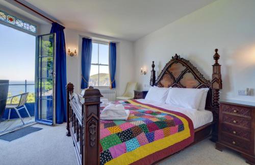 ein Schlafzimmer mit einem großen Bett mit einer bunten Decke in der Unterkunft The Orangery Lynton Cottage in Lynmouth
