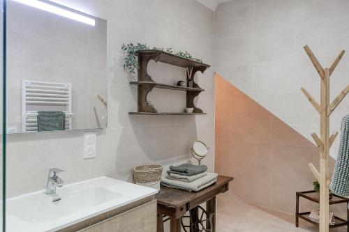 a bathroom with a sink and a mirror at Maisonnette d'Artiste au cœur des ruelles médiévales in Trévoux