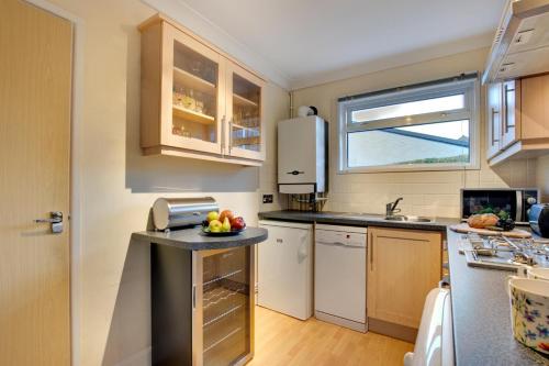 a small kitchen with white appliances and a window at 2 Clearwater in St Ives
