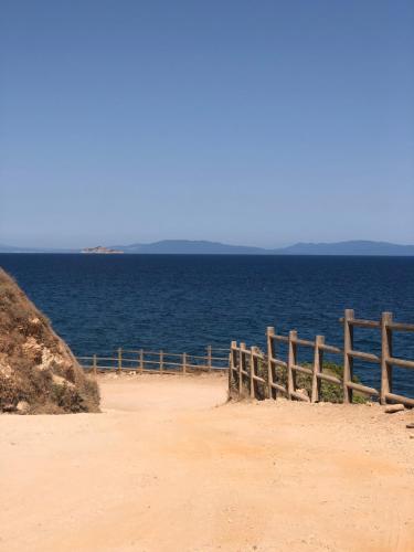 a fence on the beach near the water at Simona Elba Home in Rio nellʼElba