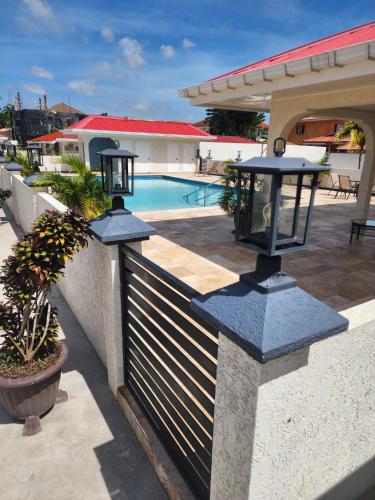 a fence with a swimming pool in front of a house at Ideal Executive Suites in Georgetown