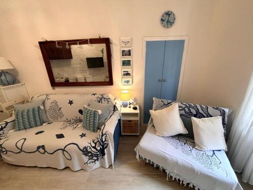 a bedroom with a bed and a couch and a mirror at Simona Elba Home in Rio nellʼElba