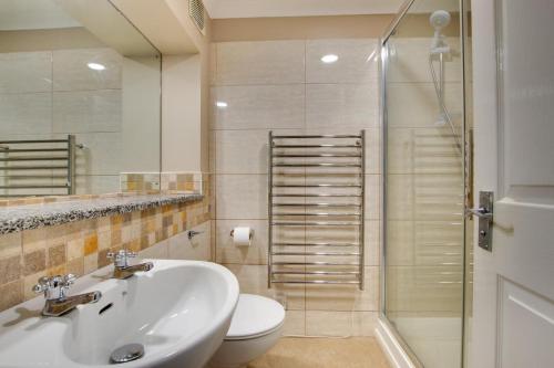Un baño con lavabo, inodoro y ducha. en Morvah 7 Zodiac House, en Saint Levan