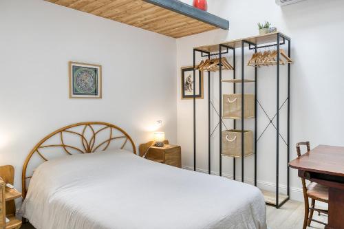 a bedroom with a white bed and a desk at Maisonnette d'Artiste au cœur des ruelles médiévales in Trévoux
