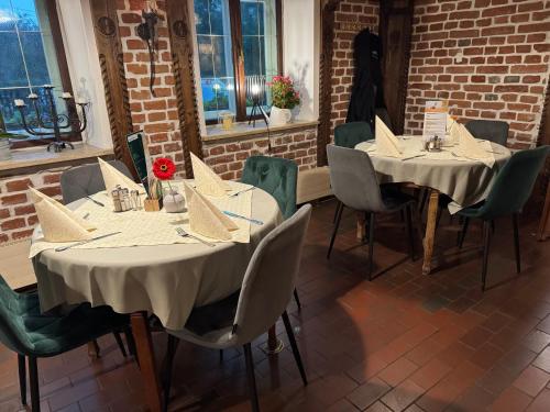 two tables and chairs in a room with a brick wall at Gasthaus Jungwirth - Family Boutique Pension in Wanghausen
