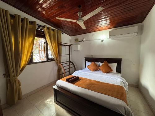 a bedroom with a bed and a window at Vintage Voyage Villa in Negombo