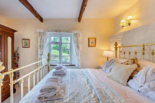 DuloeBramble Cottage - Duloe的卧室里有一张白色的大床，床边有一扇窗户