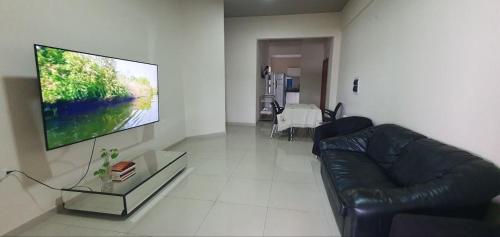 Apartamento perto de tudo no CDE في سيوداد ديل إستي: غرفة معيشة مع أريكة وتلفزيون بشاشة مسطحة
