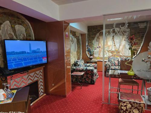 a living room with a tv and a fireplace at LEGENDS CHAMBERS by Grand Pier boutique trade mark location, 4 star rooms with unique historical themes decors with free breakfast only for king rooms and booking stays minim 4 nights in Bucharest