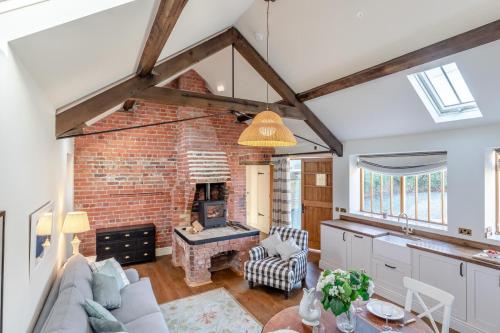 a kitchen and living room with a brick fireplace at Llangedwyn Smithy in Llangedwyn