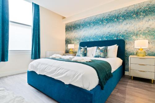 a blue bed in a bedroom with a blue wall at Stylish City Centre getaway with Cathedral Views in Canterbury