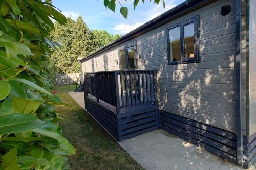 Casa azul con porche y ventana en Earl Grey Lodge - Luxury Escape near York, en Wilberfoss