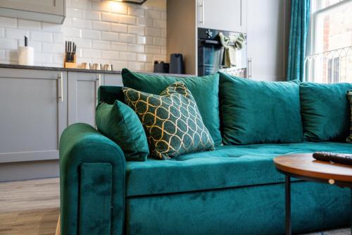 a blue couch with pillows on it in a living room at Stylish City Centre getaway with Cathedral Views in Canterbury