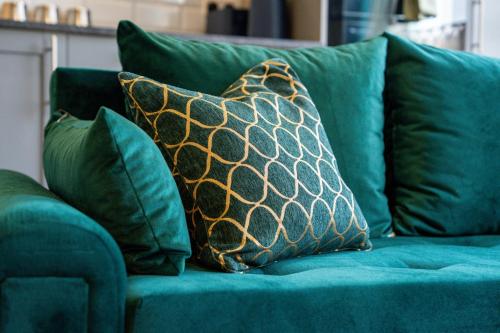 a green couch with green pillows on it at Stylish City Centre getaway with Cathedral Views in Canterbury