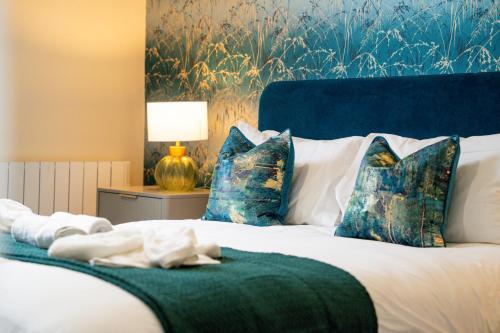 a bedroom with a bed with blue and white pillows at Stylish City Centre getaway with Cathedral Views in Canterbury