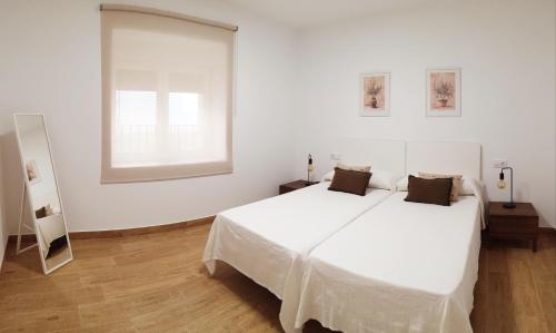 una camera da letto con un grande letto bianco e una finestra di Hoya del Agua Casa Rural a Casas de Haro