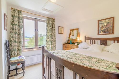 a bedroom with a bed and a window at Tump Cottage in Walford