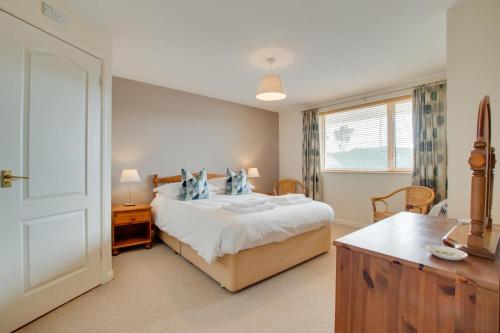 Un dormitorio con una cama y un escritorio y una ventana. en Flat 31 Clifton Court, en Croyde