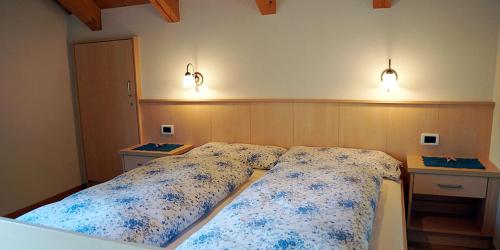 een slaapkamer met een bed en twee lampen aan de muur bij Wirthof in La Valle