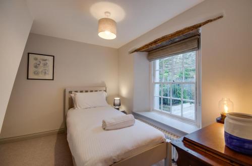 ein Schlafzimmer mit einem Bett und einem Fenster in der Unterkunft Killas Cottage in Fowey