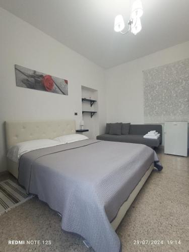 a bedroom with a large bed and a couch at I due piccioncini in Grottaminarda