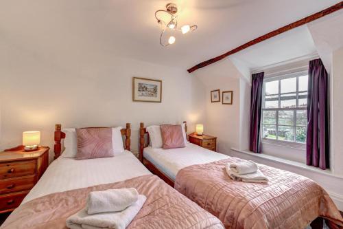 a bedroom with two beds and a window at Rose Cottage in Chapel Stile