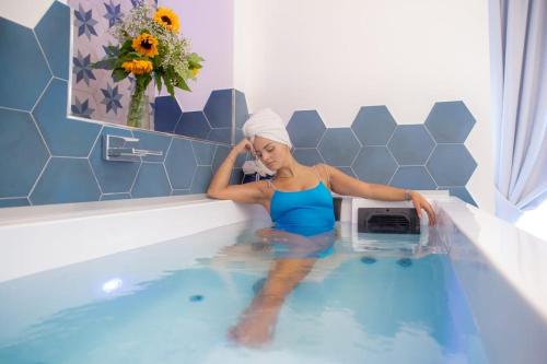 a woman is sitting in a bath tub at Maruzzé luxury room in Albori