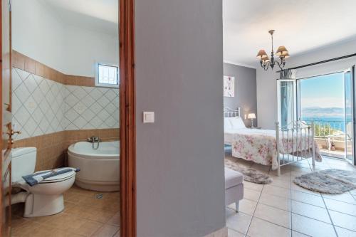 Un baño con inodoro y un dormitorio. en Villa Mylos, en Kassiopi
