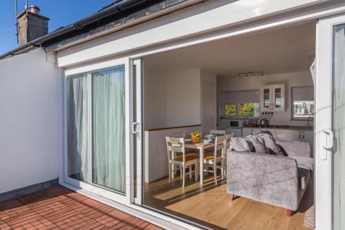 a sliding glass door leading to a kitchen and a dining room at 23 Cae Du in Abersoch