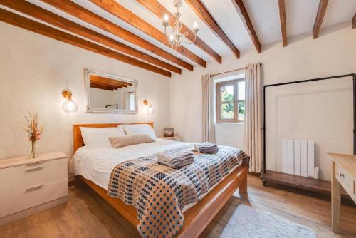 a bedroom with a bed and a dresser and a window at Hafod y Llwynog in Cross Inn