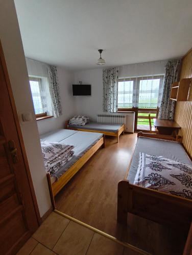 a large room with two beds and a mirror at Wynajem Pokoi Maria Sowińska in Biały Dunajec