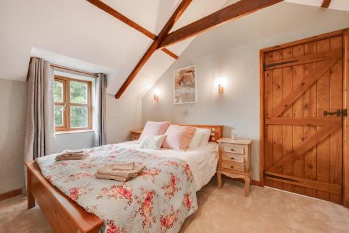 a bedroom with a bed and a wooden door at Hafod y Llwynog in Cross Inn