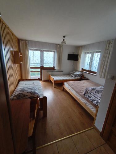 a large room with two beds and a table at Wynajem Pokoi Maria Sowińska in Biały Dunajec