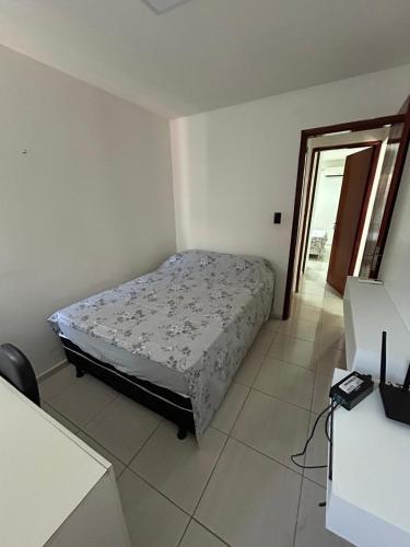a bedroom with a bed in a white room at Flat Perfeito para descansar a 400 metros da praia in Paulista