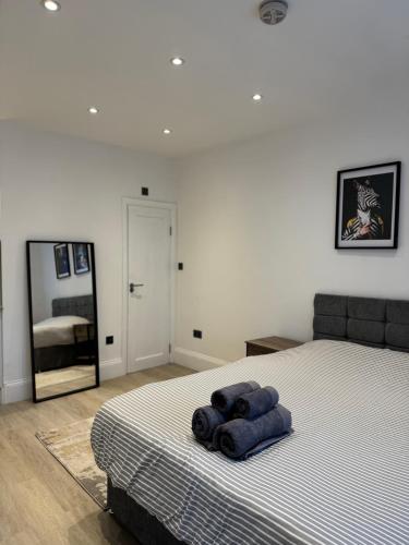 a bedroom with a bed with a blue towel on it at Chic Studio Living in Hounslow