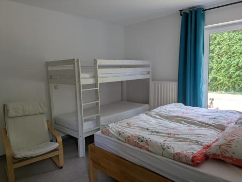 a bedroom with a bunk bed with a ladder and a chair at Ferienwohnung Familie Baus in Hammelburg